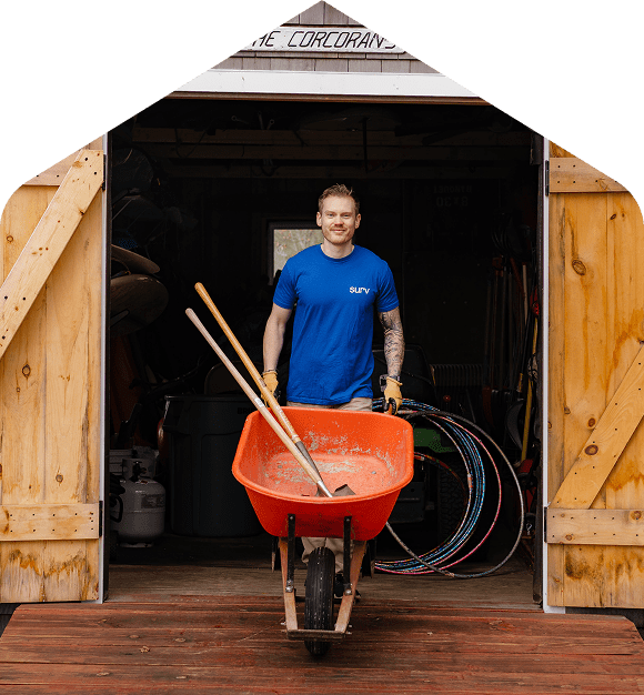 A Surv employee using a wheelbarrow